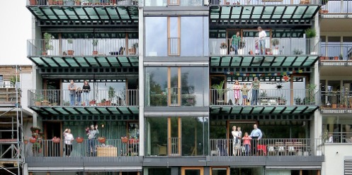 Mitglieder einer Baugemeinschaft auf den Balkonen ihres Hauses in Tübingen (Baden-Württemberg).